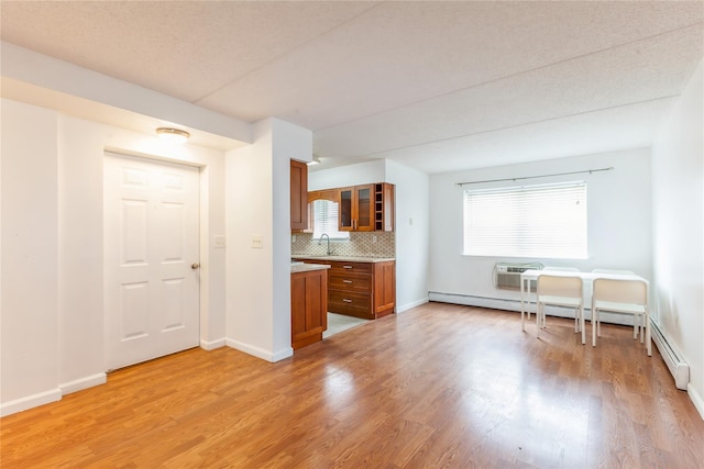 unfurnished living room featuring a textured ceiling, light wood-type flooring, and sink