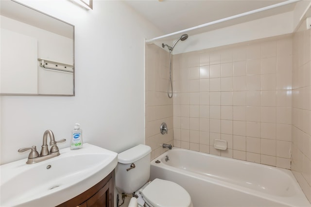 full bathroom featuring vanity, tiled shower / bath, and toilet