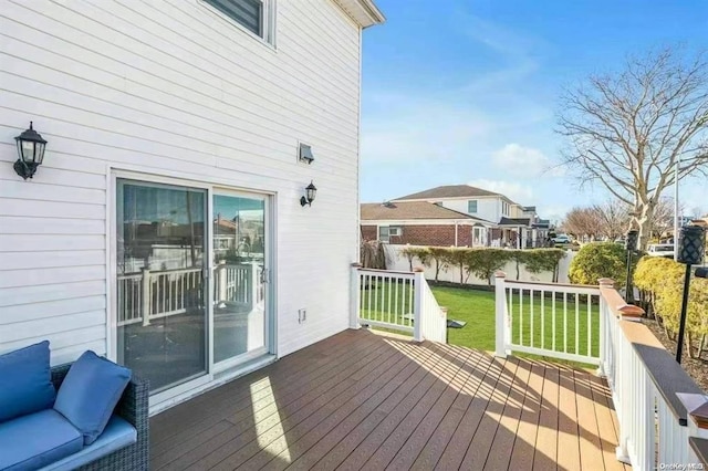 wooden deck featuring a lawn