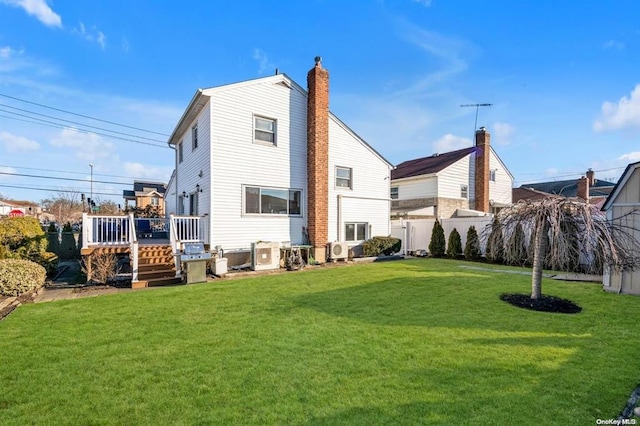 rear view of house with a wooden deck, a yard, and ac unit