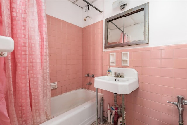 bathroom with sink, shower / tub combo, and tile walls