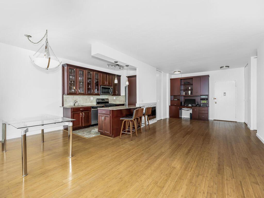 kitchen with light hardwood / wood-style flooring, decorative backsplash, a breakfast bar, a kitchen island, and appliances with stainless steel finishes