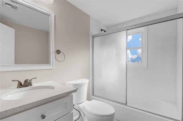 full bathroom with vanity, toilet, and bath / shower combo with glass door