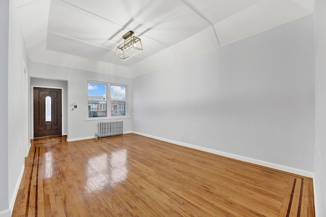 unfurnished living room with hardwood / wood-style floors and radiator heating unit