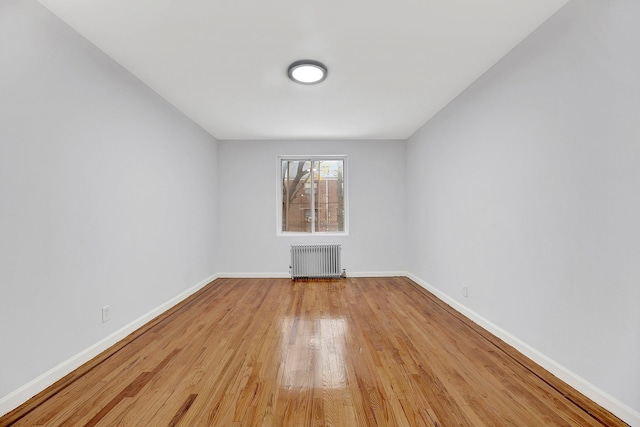 empty room featuring radiator and light wood-type flooring