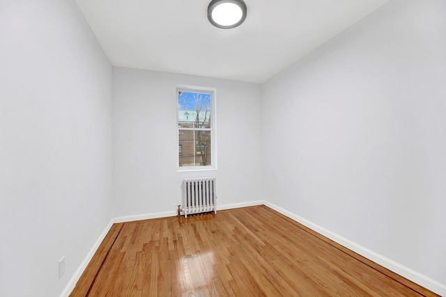 spare room featuring hardwood / wood-style flooring and radiator