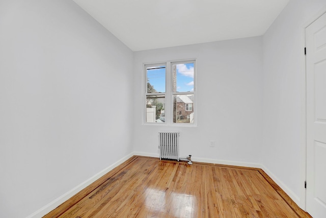 empty room featuring hardwood / wood-style floors and radiator