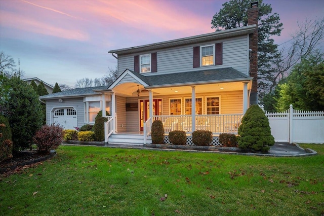 view of front property featuring a lawn, a porch, and a garage