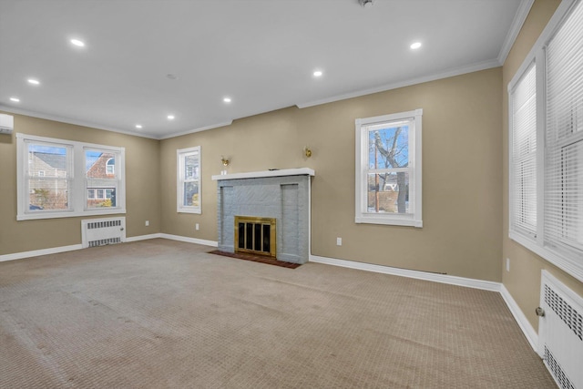 unfurnished living room featuring light carpet, radiator heating unit, a brick fireplace, and crown molding