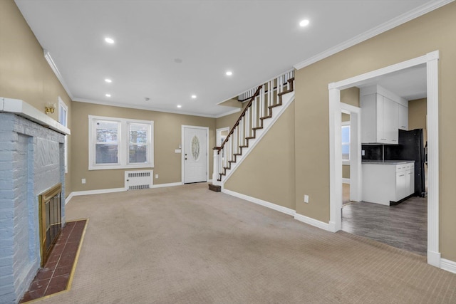 unfurnished living room with a fireplace, radiator heating unit, light colored carpet, and ornamental molding