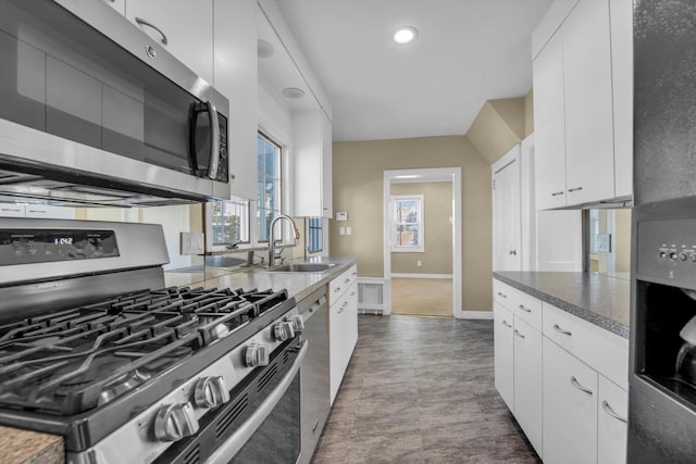 kitchen featuring stainless steel appliances, white cabinetry, and sink