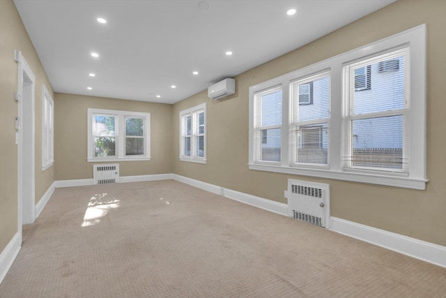 empty room featuring radiator, light carpet, and a wall mounted air conditioner