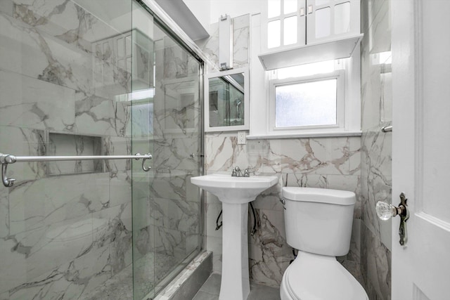 bathroom featuring toilet, tile walls, a shower with shower door, and sink