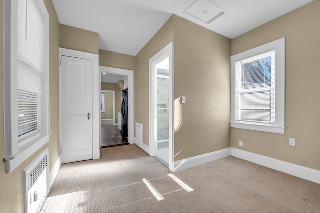 spare room featuring light colored carpet