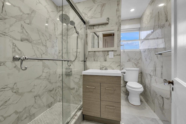 bathroom featuring vanity, toilet, a shower with door, and tile walls