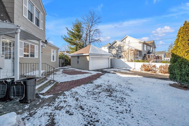 yard covered in snow featuring an outdoor structure and a garage