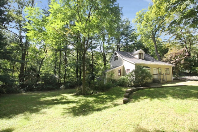 view of side of home with a yard