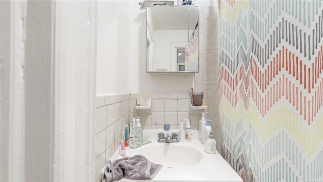 bathroom with sink and tile walls