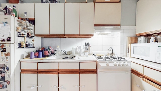 kitchen featuring white cabinetry, sink, white appliances, and backsplash