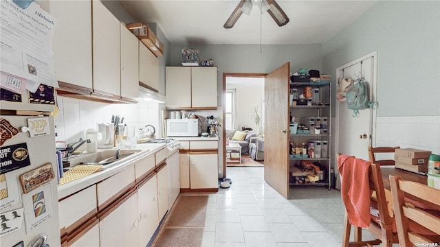 kitchen featuring light tile patterned flooring, sink, and ceiling fan