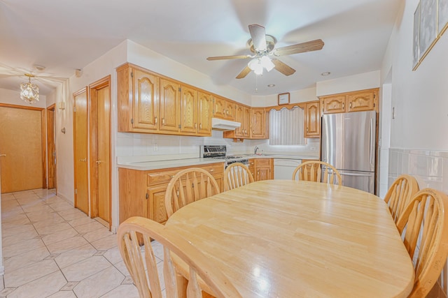 kitchen with stainless steel refrigerator, dishwasher, stove, light tile patterned flooring, and ceiling fan with notable chandelier