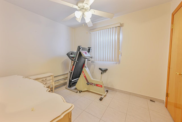 exercise area with ceiling fan and light tile patterned flooring