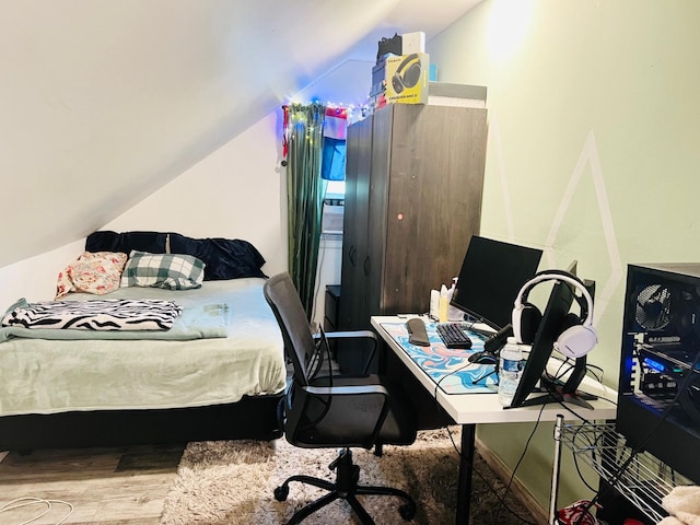 bedroom with hardwood / wood-style floors and lofted ceiling