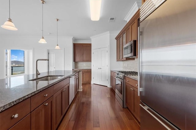 kitchen with tasteful backsplash, sink, hanging light fixtures, and high end appliances