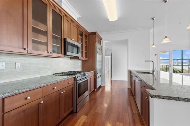 kitchen featuring crown molding, sink, wood-type flooring, pendant lighting, and high quality appliances