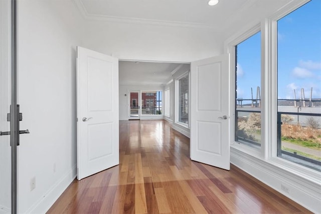 hall with hardwood / wood-style floors and ornamental molding