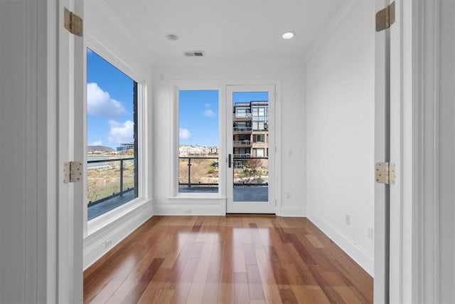 spare room with crown molding and hardwood / wood-style flooring