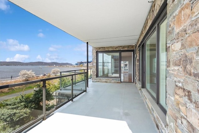 balcony featuring a water and mountain view