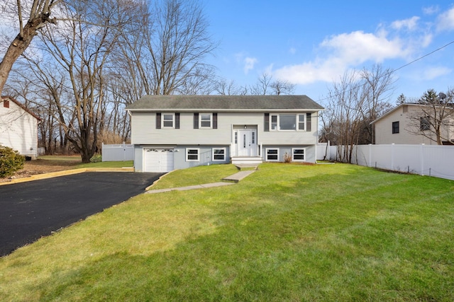 raised ranch featuring a front lawn and a garage