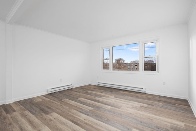 spare room featuring hardwood / wood-style flooring, ornamental molding, and a baseboard heating unit