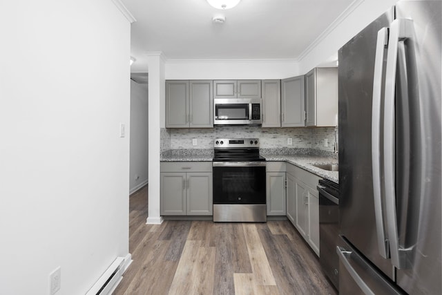 kitchen with gray cabinetry, backsplash, and stainless steel appliances