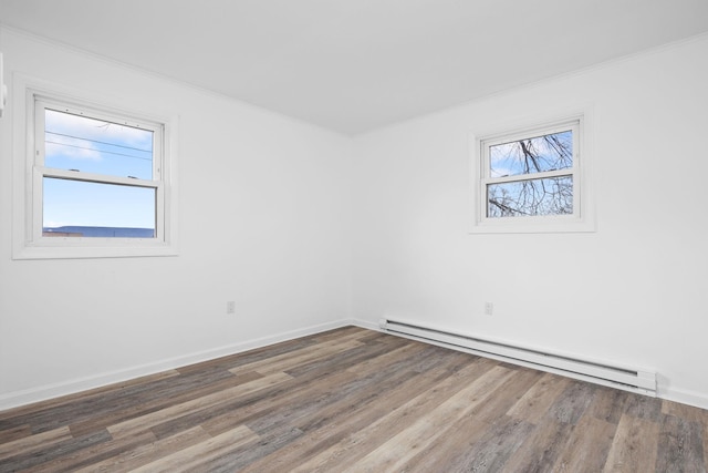 spare room featuring ornamental molding, dark wood-type flooring, and a baseboard radiator