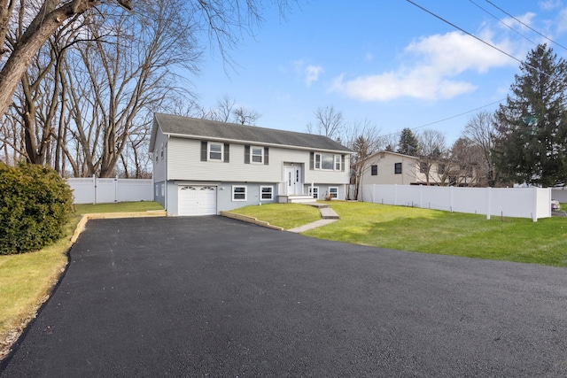 bi-level home featuring a garage and a front lawn