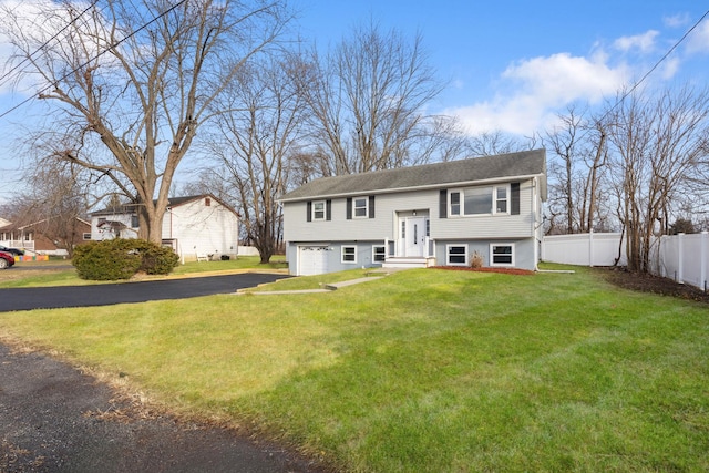 raised ranch featuring a front lawn and a garage