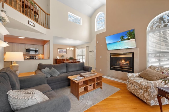 living room featuring a fireplace, a chandelier, and light wood-type flooring