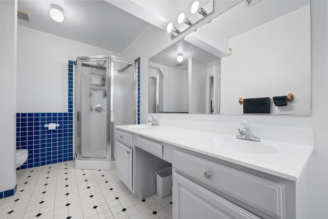 bathroom with toilet, an enclosed shower, tile walls, vanity, and tile patterned flooring