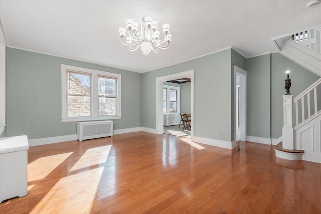 unfurnished dining area with light hardwood / wood-style floors, ornamental molding, radiator, and a chandelier