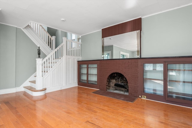 unfurnished living room featuring crown molding, a fireplace, and light hardwood / wood-style flooring