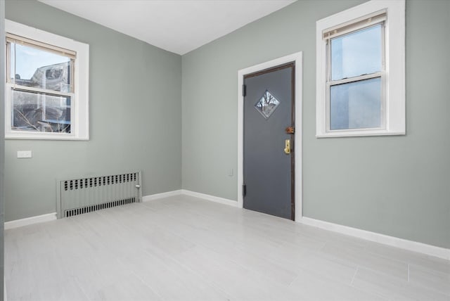 unfurnished room with radiator heating unit