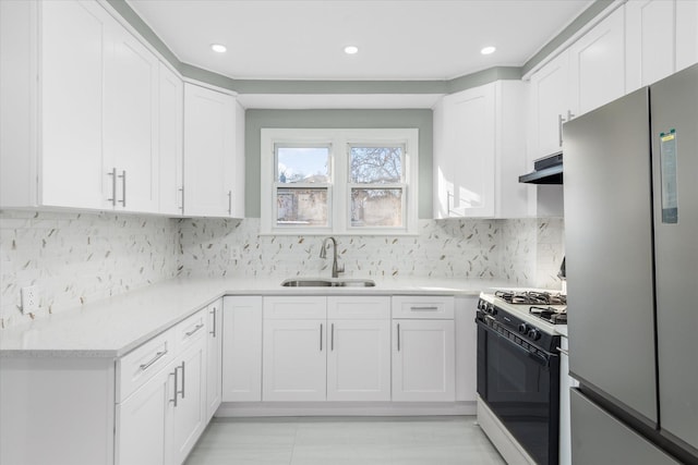 kitchen featuring white cabinetry, white gas range oven, sink, and stainless steel refrigerator