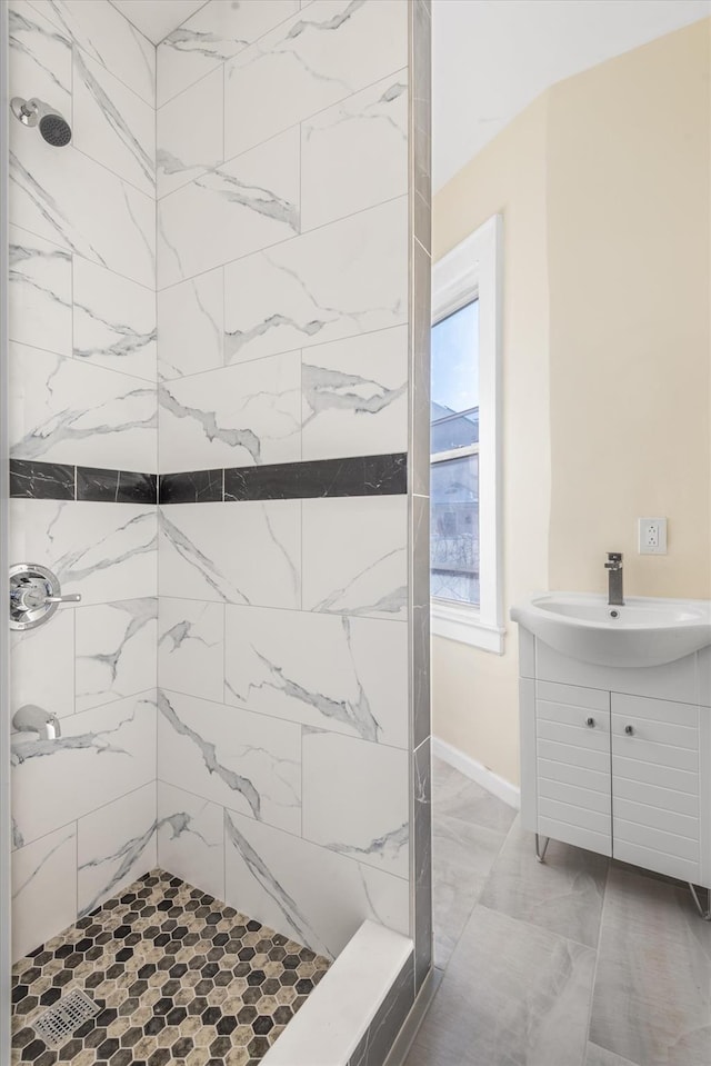 bathroom with tiled shower and sink