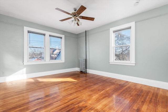 unfurnished room with radiator, ceiling fan, and hardwood / wood-style floors