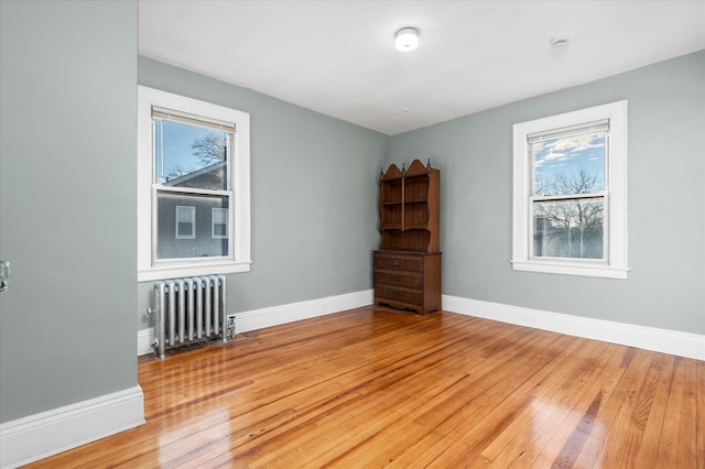 unfurnished room with radiator and light hardwood / wood-style flooring