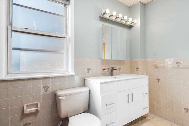 bathroom featuring tile patterned flooring, vanity, tile walls, and toilet