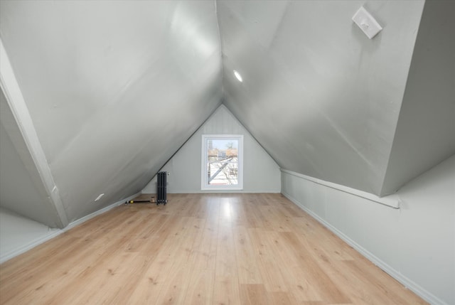 additional living space featuring lofted ceiling and light wood-type flooring