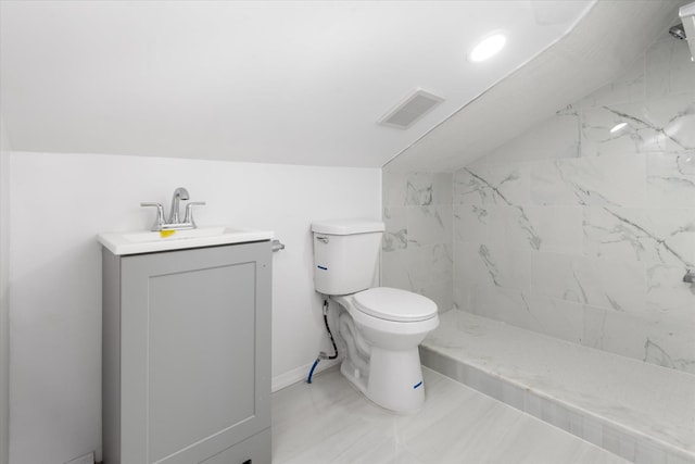 bathroom with a shower, vanity, lofted ceiling, and toilet